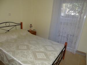 1 dormitorio con cama y ventana grande en PERLIA comfortable and relaxing apartment, en Poros