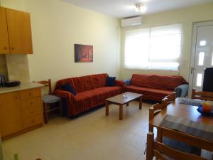 sala de estar con sofá rojo y mesa en PERLIA comfortable and relaxing apartment, en Poros
