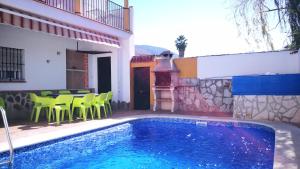 a villa with a swimming pool and a table and chairs at Casa La Vega in El Bosque