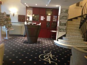 a lobby with a staircase and a stair case at Hotel de France in Bergerac