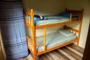 two bunk beds in a room with blue curtains at Casa tranquila perto da Joaquina in Florianópolis