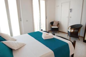 カットーリカにあるHotel Rizのベッドルーム1室(青と白のベッド1台、椅子2脚付)