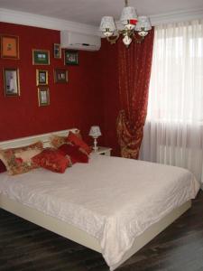オデッサにあるApartment on Skvortsova 4aの赤い壁のベッドルーム1室(大型ベッド1台付)