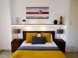 una camera da letto con un letto con lenzuola gialle e due lampade di Apartment Duquesa de España a Torremolinos