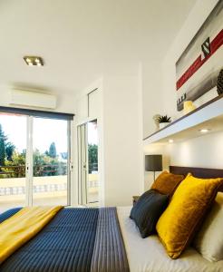 トレモリノスにあるApartment Duquesa de Españaのベッドルーム1室(大型ベッド1台、黄色と青の枕付)