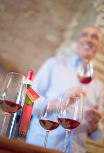 drie glazen wijn op een tafel met een man bij Cinigiano in Cinigiano
