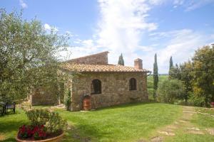 een stenen huis met een tuin met groen gras bij Cinigiano in Cinigiano