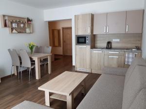 a living room with a couch and a table and a kitchen at Apartman Jasná Lúčky in Demanovska Dolina