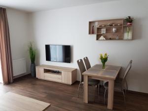 a living room with a table and a tv at Apartman Jasná Lúčky in Demanovska Dolina