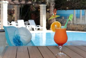 a drink sitting on a table next to a pool at Petra Beach Hotel in Hersonissos