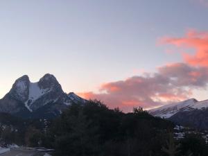 una puesta de sol sobre una cordillera con montañas cubiertas de nieve en Hostal La Cuineta de Cal Triuet, en Gósol