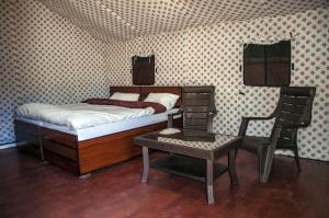 a small bedroom with a bed and a chair at Jungle Stays in Chail
