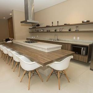 una cocina con una gran mesa de madera y sillas blancas. en Soul Paulista|Frei Caneca, en São Paulo