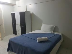 a bedroom with a bed with a blue blanket at Asa Norte in Brasilia