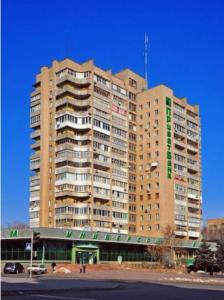 a large tall building in front of a parking lot at Apartments NEW in Mykolaiv