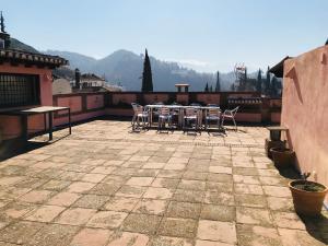 un patio avec des chaises et une table sur un toit dans l'établissement Carmen De La Candelaria, à Grenade