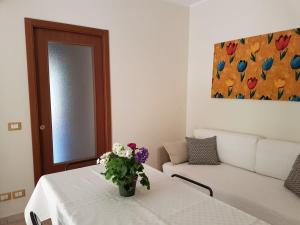 a living room with a table with a vase of flowers on it at Appartamento Vacanza Gliaca in Piraino