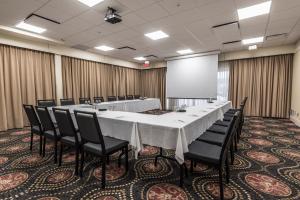 duża sala konferencyjna z długim stołem i krzesłami w obiekcie Hotel & Suites Le Dauphin Drummondville w mieście Drummondville