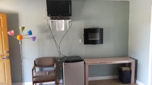 a room with a desk with a television and a chair at Black Hawk Lodge in Coarsegold