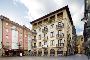 a large building with balconies on a city street at Pensi&oacute;n Txiki Polit in Zarautz