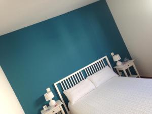コティージョにあるBluesunのベッドルーム1室(青い壁の白いベッド1台付)