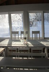 a table and chairs in a room with snow on the windows at Valonranta Cottage in Kalmari