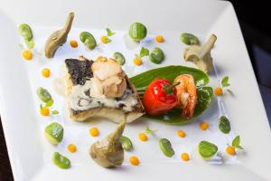 a white plate with a piece of food and vegetables at B&B Villa sensorielle in Nice