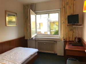 a small bedroom with a bed and a window at Hotel Marienhof Düsseldorf Neuss in Neuss