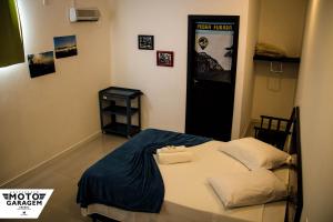 - une petite chambre avec un lit et une couverture bleue dans l'établissement MotoGaragem, à Urubici
