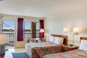 a hotel room with two beds and a balcony at Anchorage Inn & Marina in Ocracoke