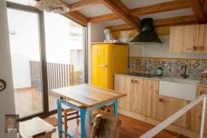 una cucina con tavolo e frigorifero giallo di Dúplex del Arco a Cangas de Morrazo