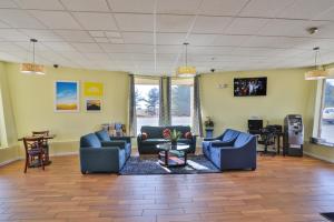 a living room with blue couches and a table at Days Inn by Wyndham Wrightstown McGuire AFB Bordentown in Wrightstown