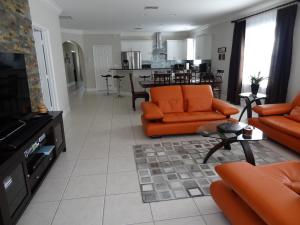 a living room with orange furniture and a kitchen at Luxury and the beach in Naples