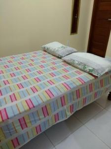 a bed with a colorful comforter on top of it at CASA para até 10 PESSOAS in Boa Vista