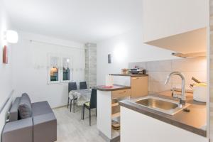 cocina y sala de estar con fregadero y mesa en Apartment Sali Dugi Otok, en Sali