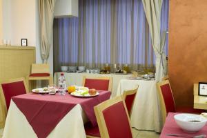 uma sala de jantar com duas mesas com pratos de comida em Hotel Catania Town em Catânia