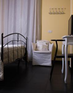 um quarto com uma cama, uma cadeira e uma secretária em La Casetta B&B em Cernusco sul Naviglio