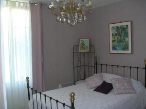 - une chambre avec un lit et un lustre dans l'établissement Appartements Villa Odette, à Bagnoles-de-l'Orne