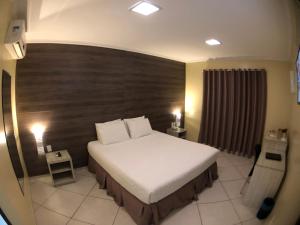 Floriano的住宿－Garoto Park Hotel，一间卧室配有一张大床和木制床头板