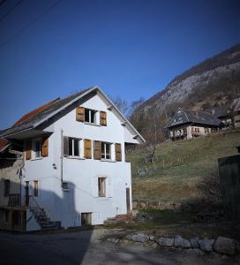 a white house on a hill with a mountain at La Fougère in Thoiry