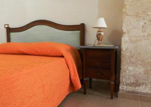 シクリにあるLe volte di Giudittaのベッド(オレンジの毛布、ナイトスタンドのランプ付)