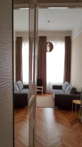 sala de estar con sofá y sala de estar con espejo. en CBS Apartments Budapest, en Budapest