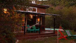 uma pequena casa com um deque e uma piscina em Samsara Traslasierra em Los Hornillos