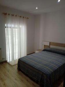 a bedroom with a bed and a large window at Alojamiento Samumari in Ciudad-Rodrigo