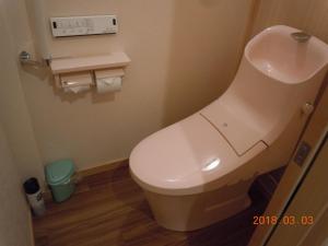 a bathroom with a white toilet in a room at Yuuhiken in Asago