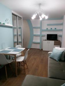ein Wohnzimmer mit einem Tisch und einem Sofa in der Unterkunft Two-bedroom apartment in the center in Chmelnyzkyj