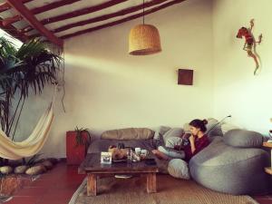 a woman sitting on a couch in a living room at La Casa de Hercilia Boutique in Barichara