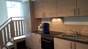 a kitchen with wooden cabinets and a sink and a staircase at Ötscherblick Fam Winter in Frankenfels