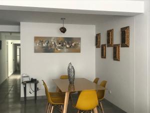 uma sala de jantar com uma mesa e cadeiras amarelas em Cusco Cozy Apartment em Cusco