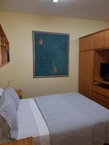 1 dormitorio con 1 cama y una pintura en la pared en OKE Apart Hotel en San Lorenzo